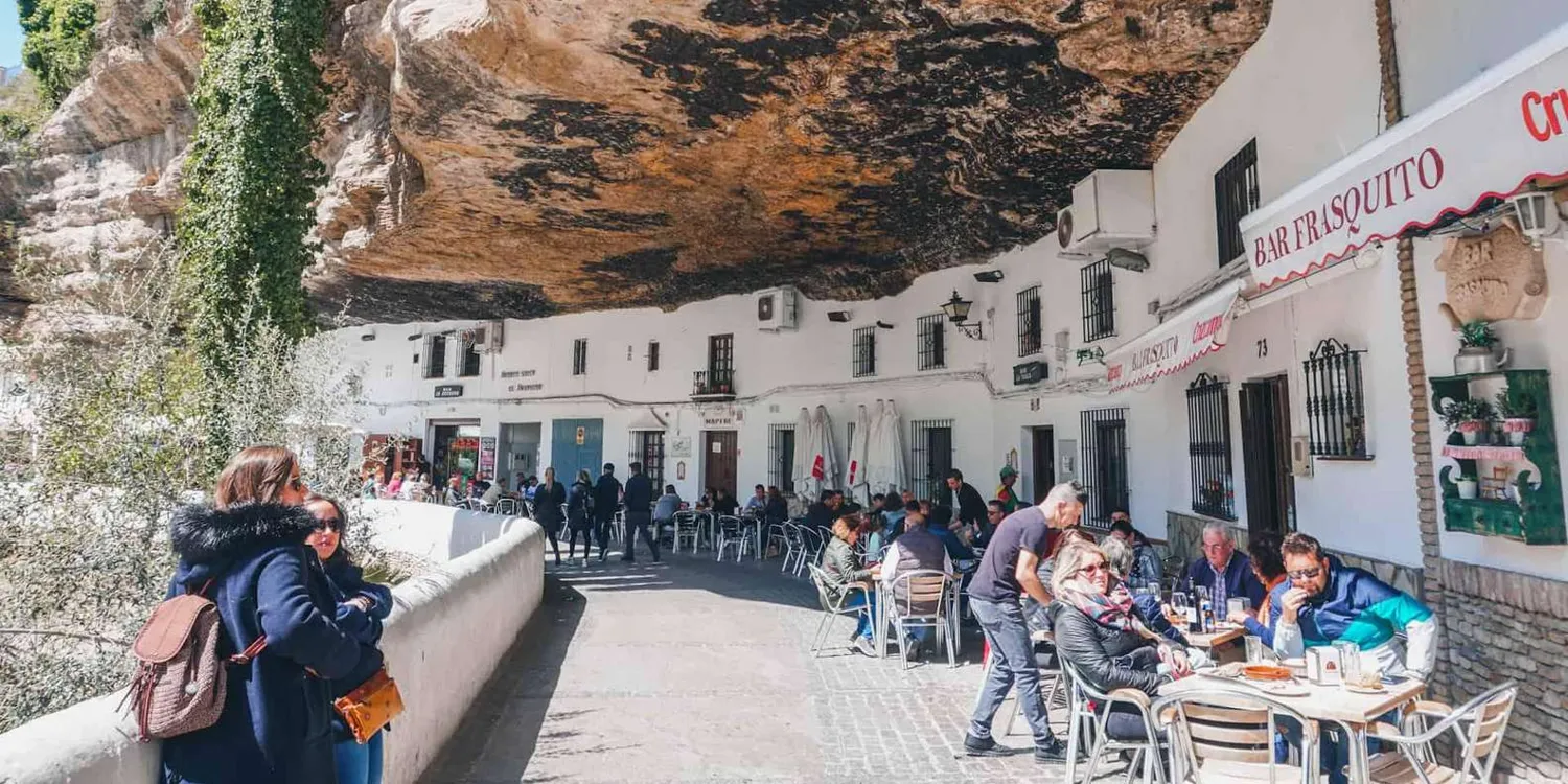 Setenil street with white houses below a rock overhang